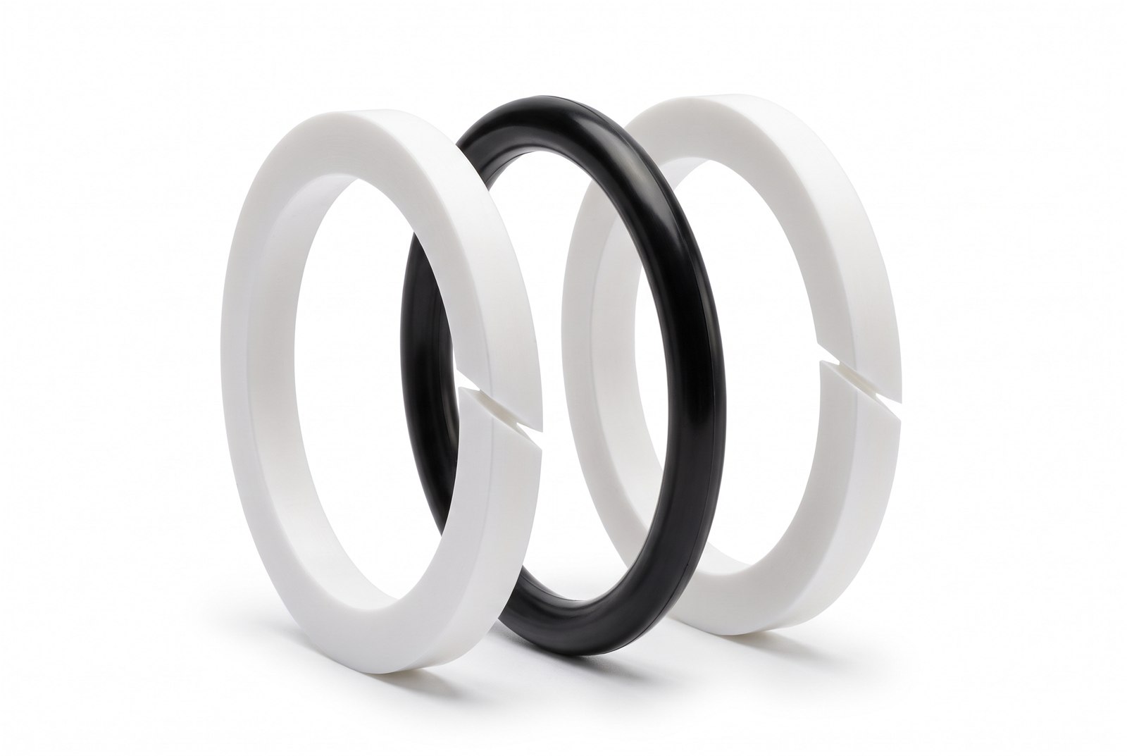 Two white split PTFE backup rings flanking a black O-Ring of the same size, the double back-up arrangement for bidirectional pressure